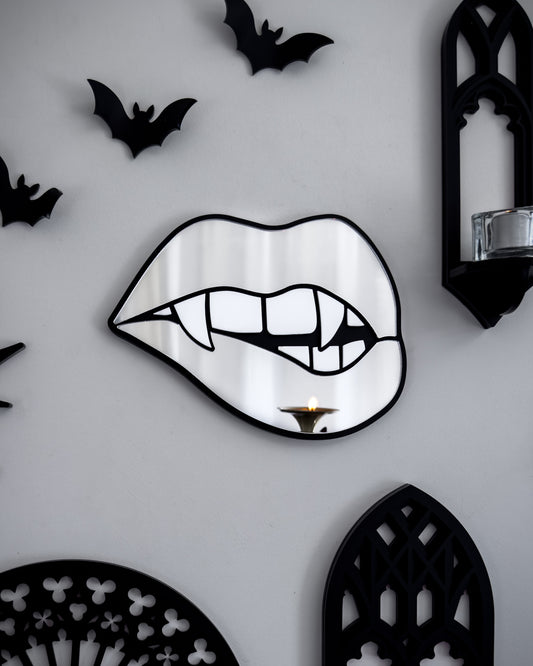Silver mirror vampire lips wall art styled on a gothic gallery wall with black bats, cathedral shelf, and candlelight