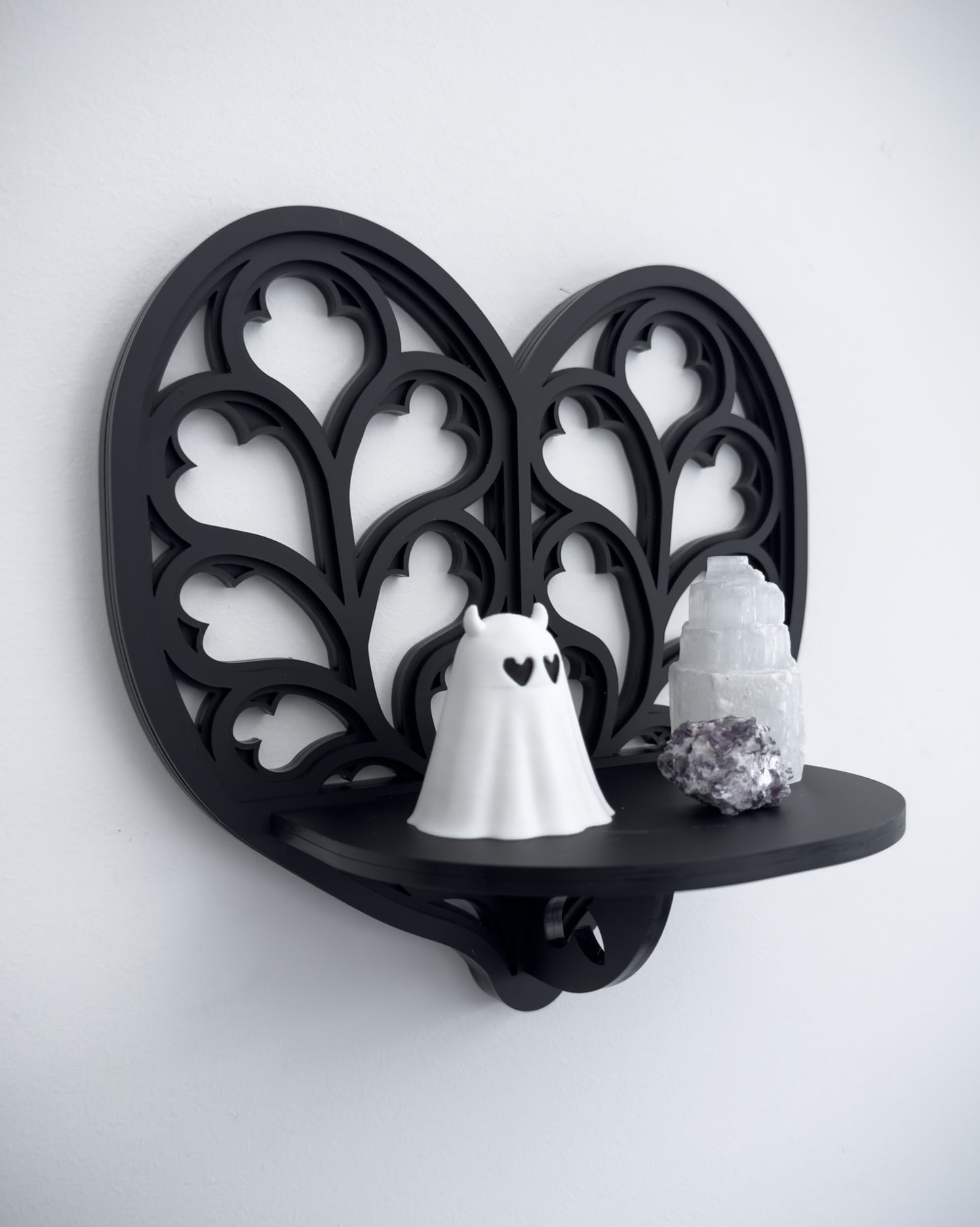 Close-up of Heart of Yorkshire cathedral tracery wall shelf in black layered acrylic holding crystals and trinkets