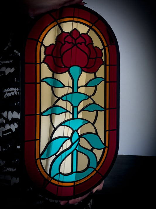 Gothic stained glass style wall mirror held in hand for scale, red, gold and teal acrylic design