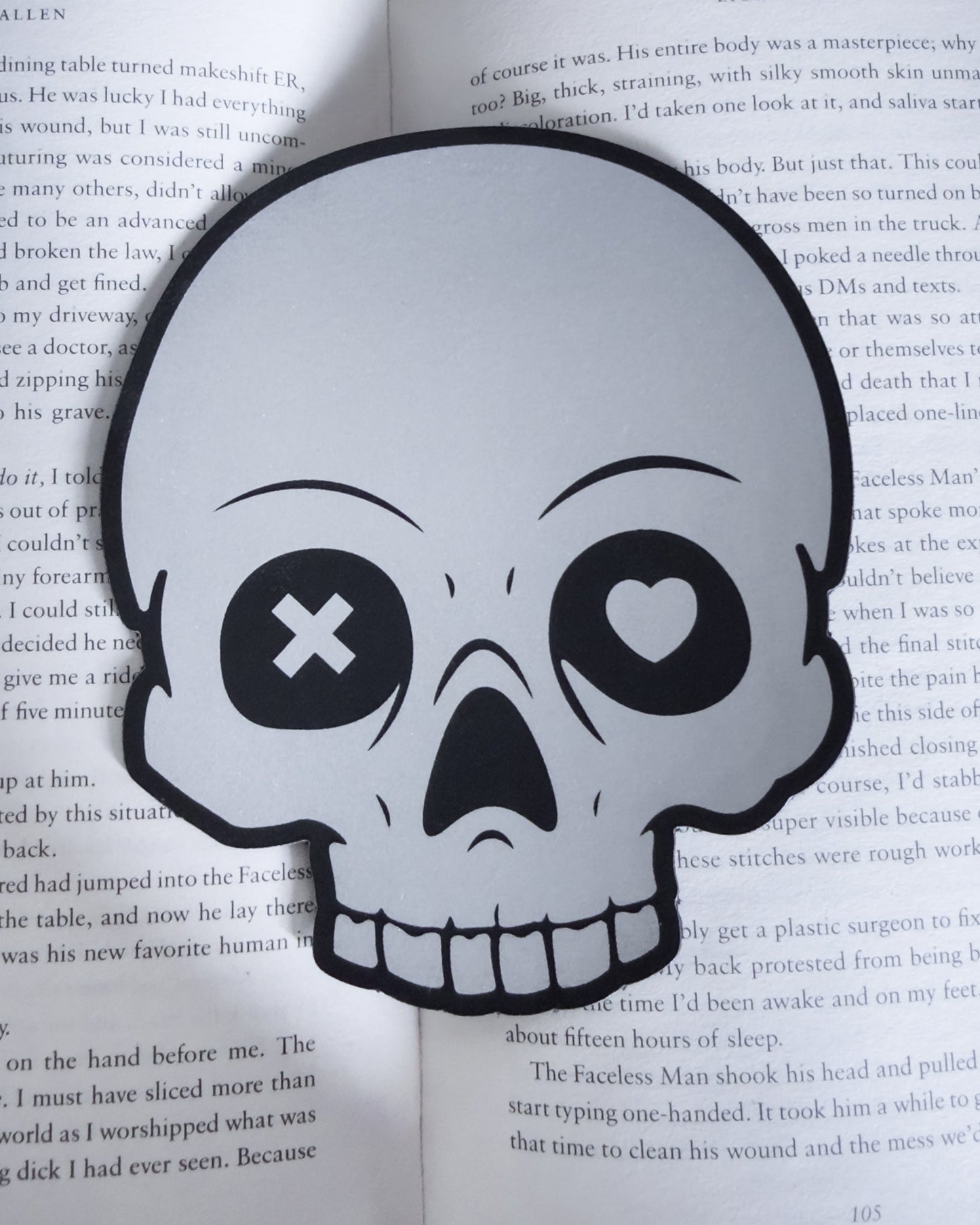 Gothic skull bookmark in black and silver leatherette, resting in a open book