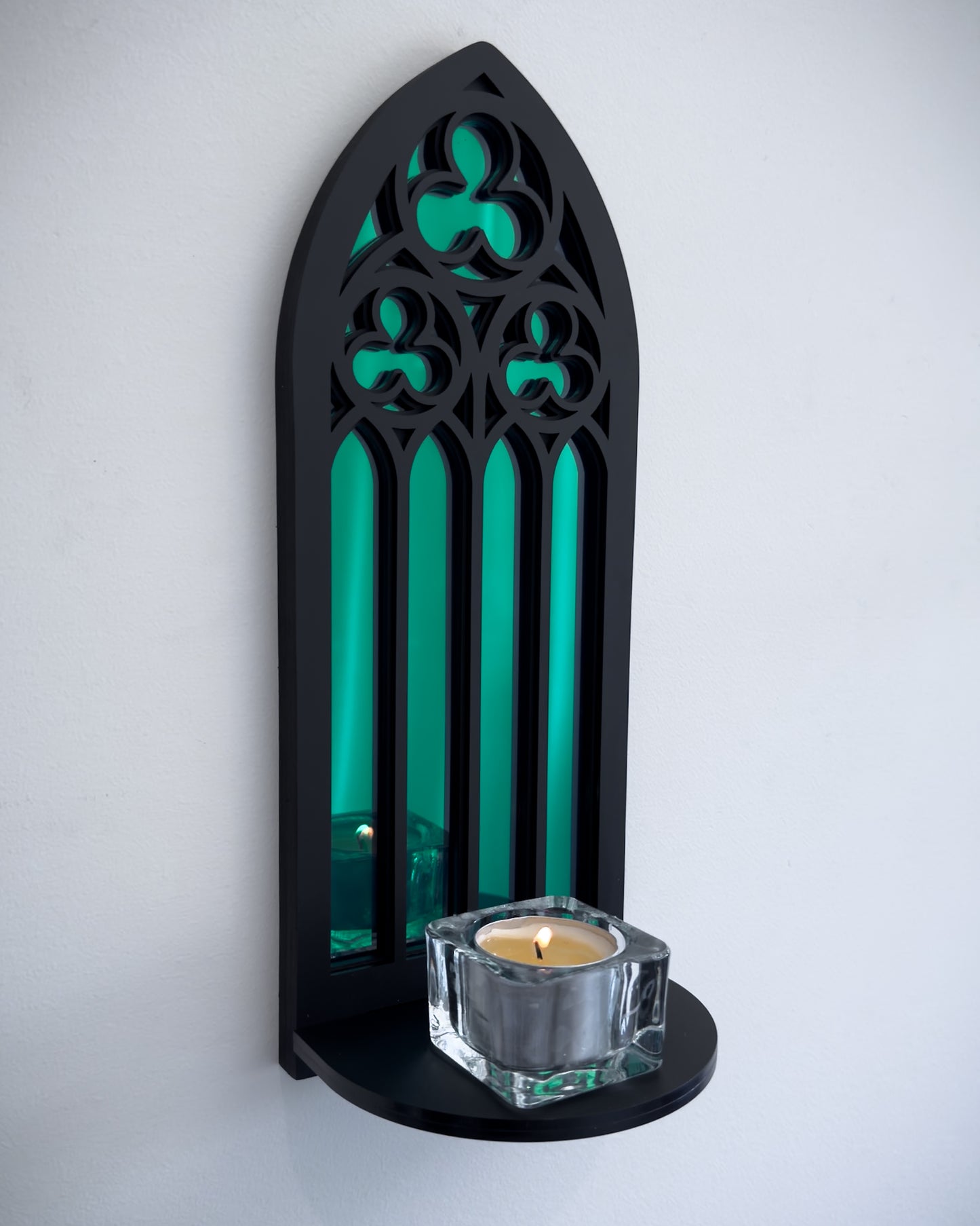 Side view of gothic cathedral wall shelf in black layered acrylic with green acrylic mirror inset and candle display