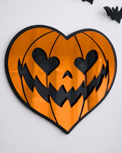 Orange heart-shaped pumpkin mirror wall art in layered black acrylic on a bright cool-toned wall