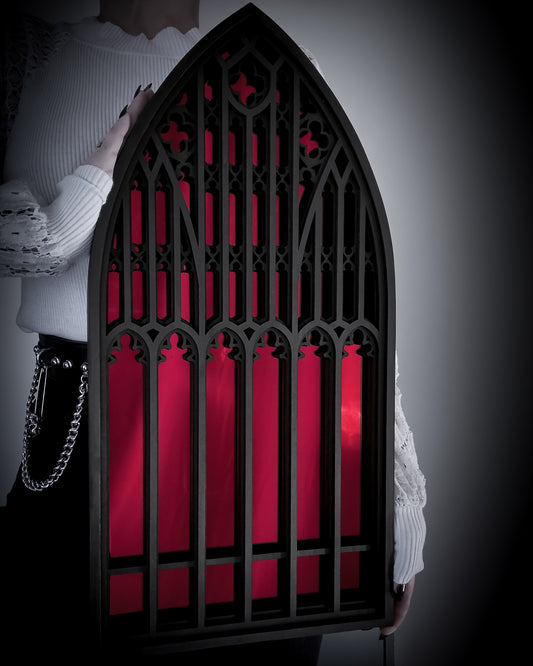 Salem Witch Museum Cathedral Mirror in black layered wood with red acrylic mirror, shown held for scale.