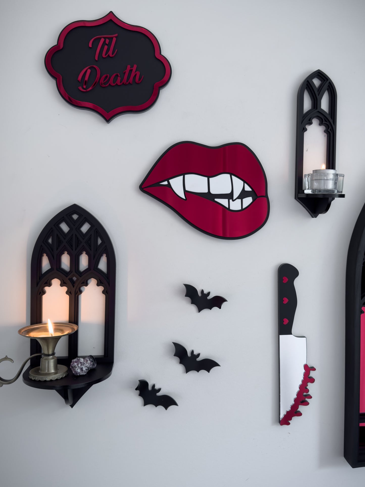 Gothic gallery wall featuring bloody knife mirror wall art with bats, candle shelf and red lips decor