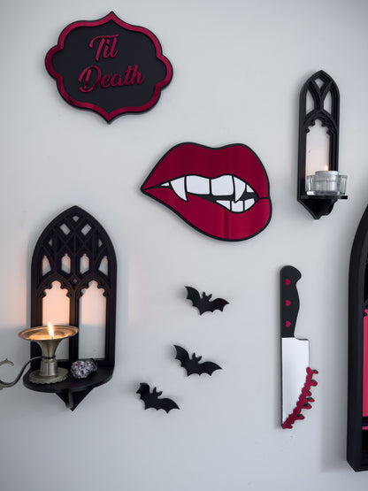 Gothic gallery wall featuring bloody knife mirror wall art with bats, candle shelf and red lips decor