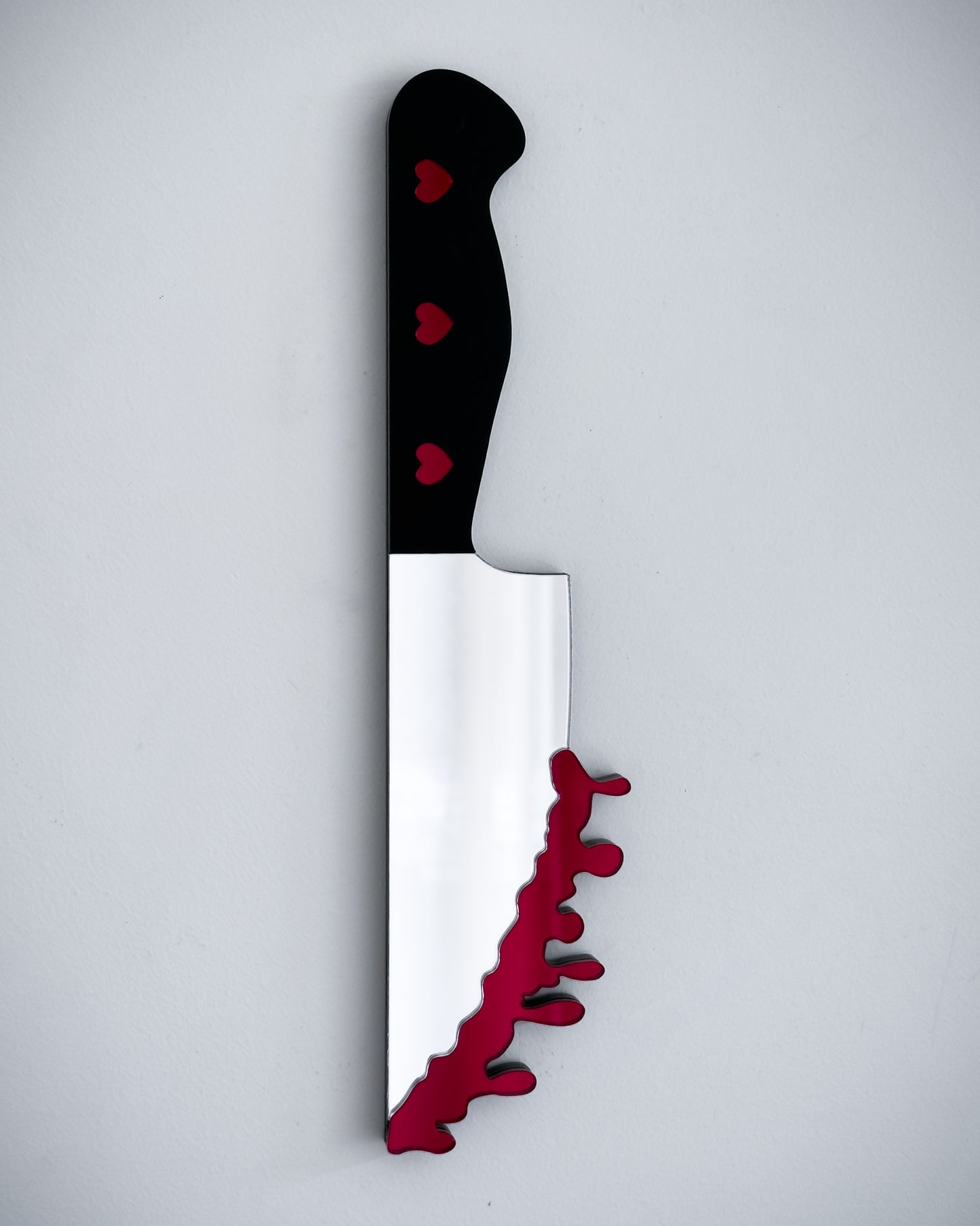 Bloody knife mirror wall art with heart handle on white wall