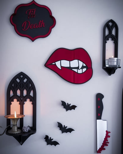 Gallery wall featuring gothic cathedral wall shelf, vampire lips mirror, acrylic bats, bloody knife wall decor and ‘Til Death sign.