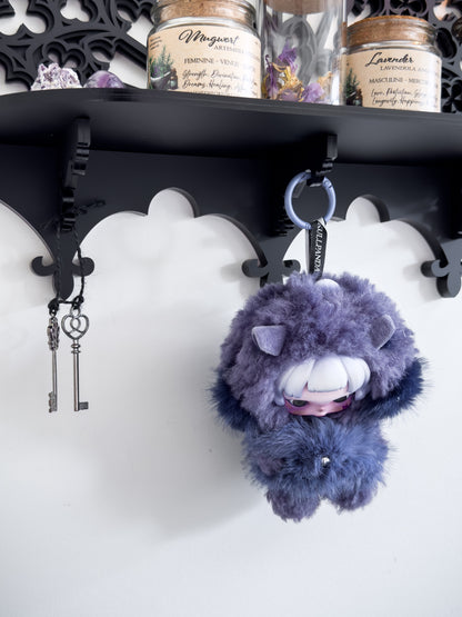 Close-up of gothic wall shelf underside showing ornate bracket detail and hanging hooks