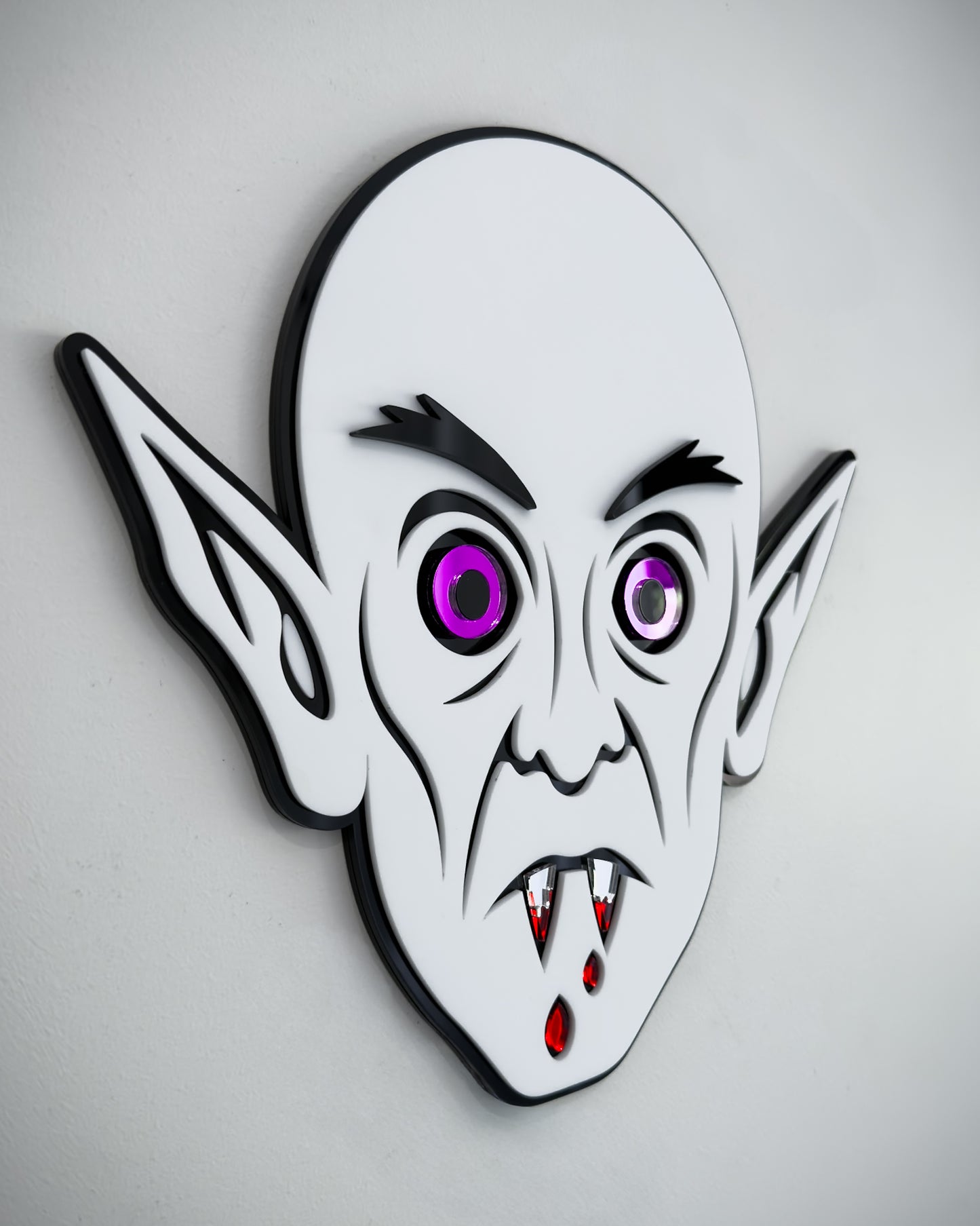 Side view of Nosferatu vampire face wall art in black and white acrylic with mirror purple eyes and blood detail