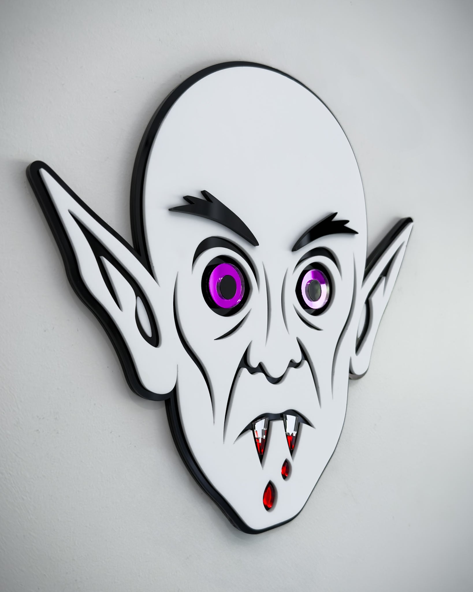 Side view of Nosferatu vampire face wall art in black and white acrylic with mirror purple eyes and blood detail