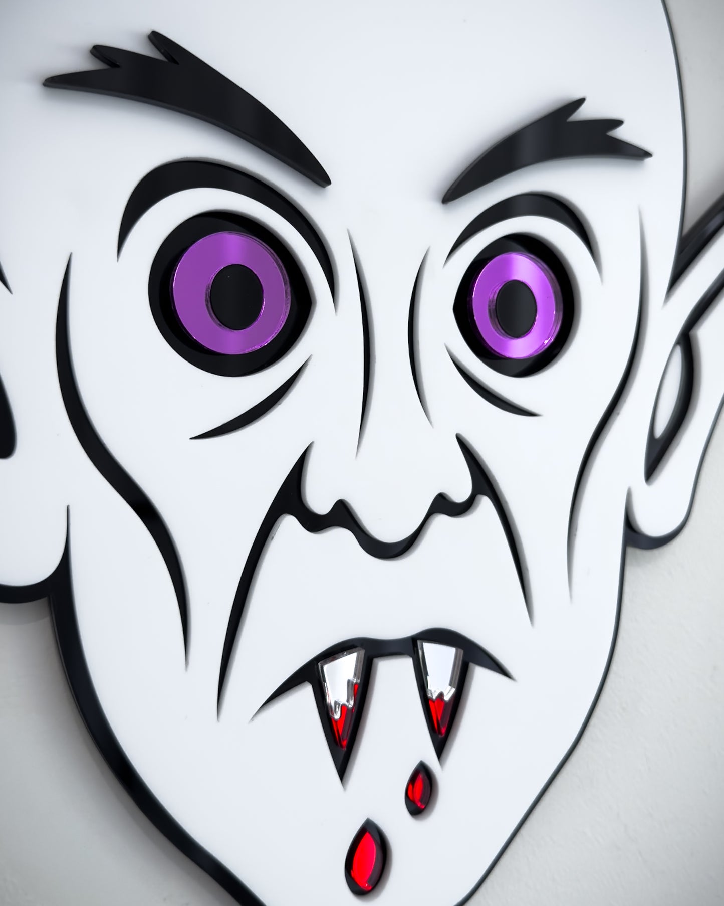 Close-up of Nosferatu vampire face mirror wall art in black and white acrylic with mirror purple eyes and blood detail