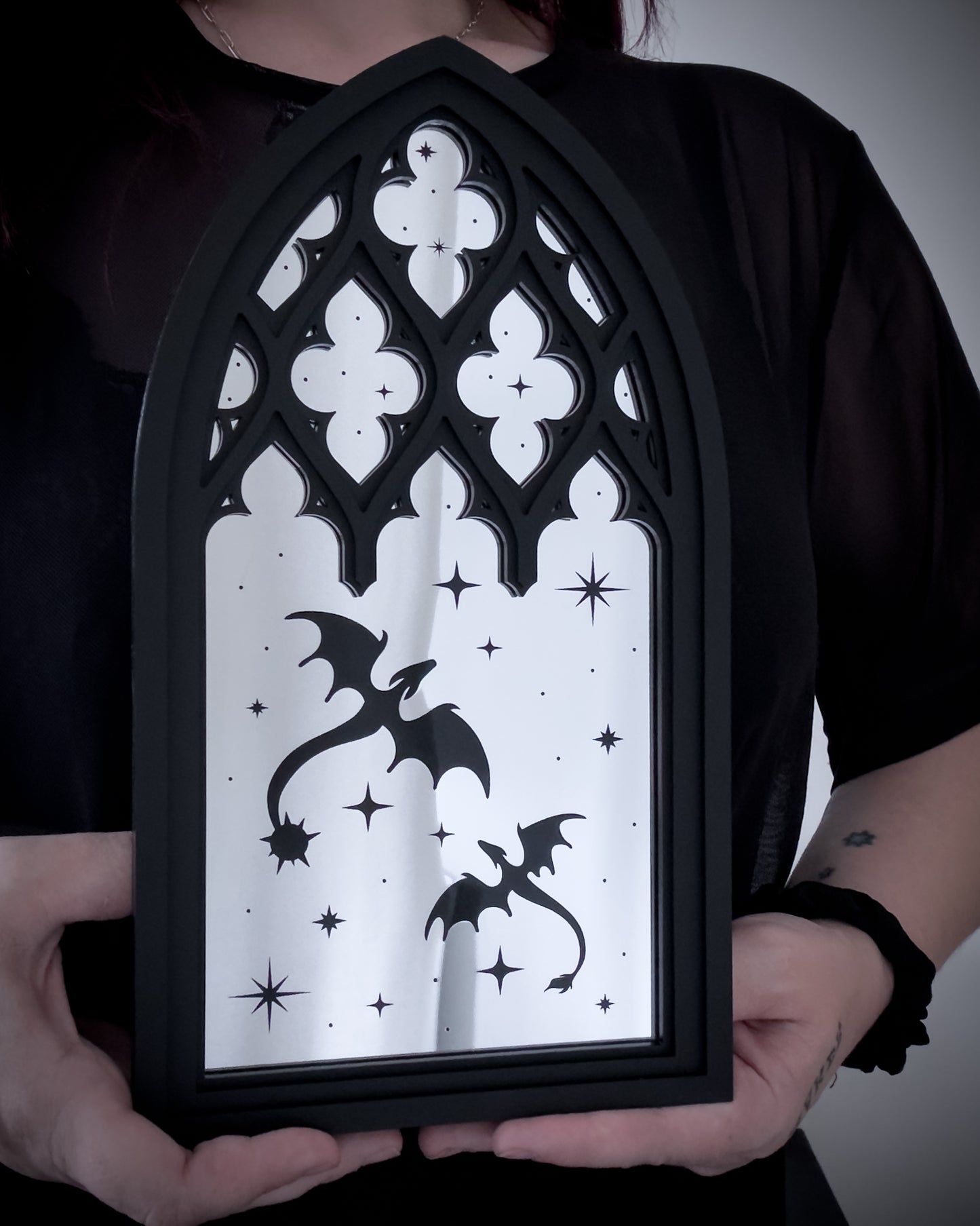 Gothic cathedral dragon window mirror in silver acrylic held for size reference