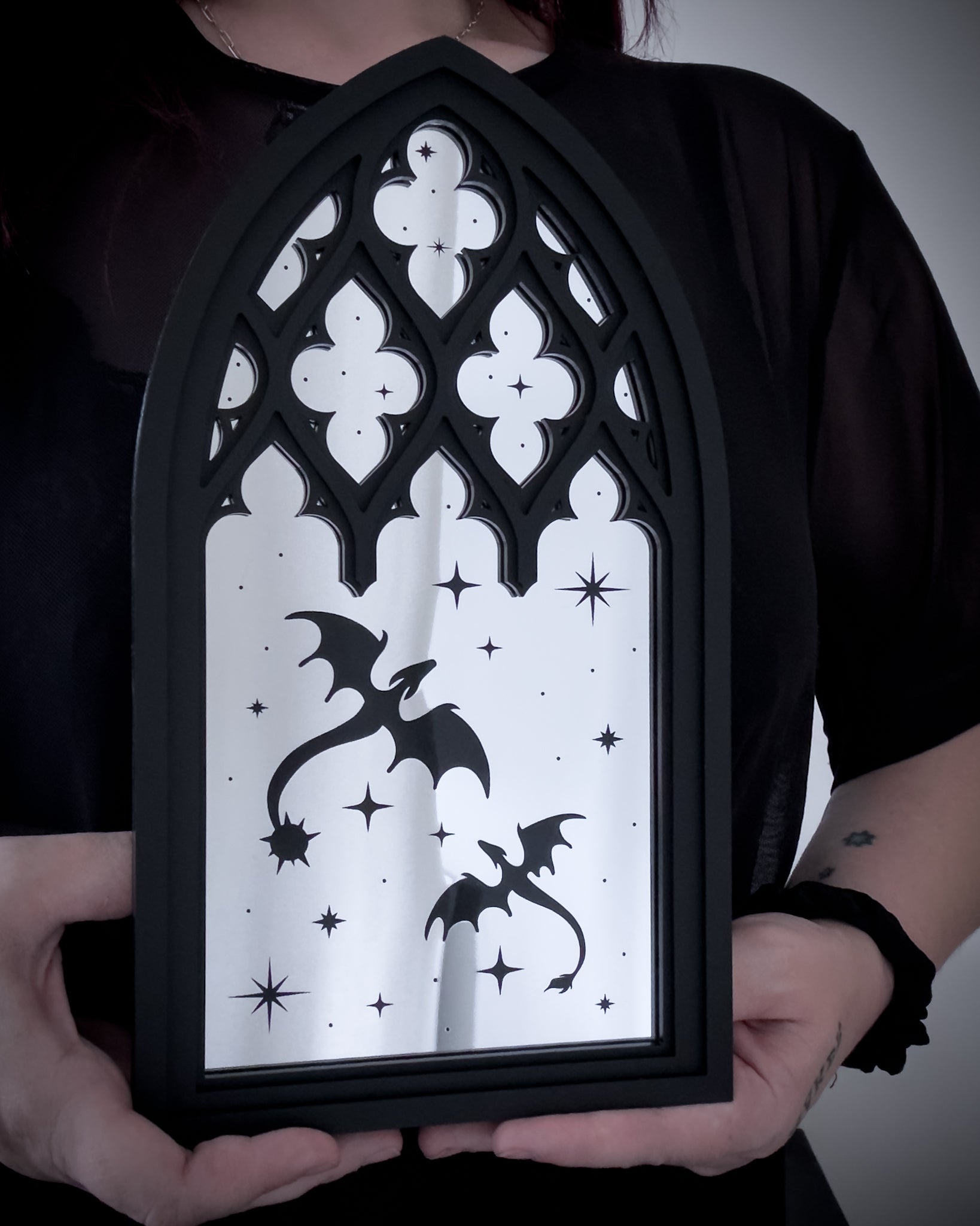 Gothic cathedral dragon window mirror in silver acrylic held for size reference