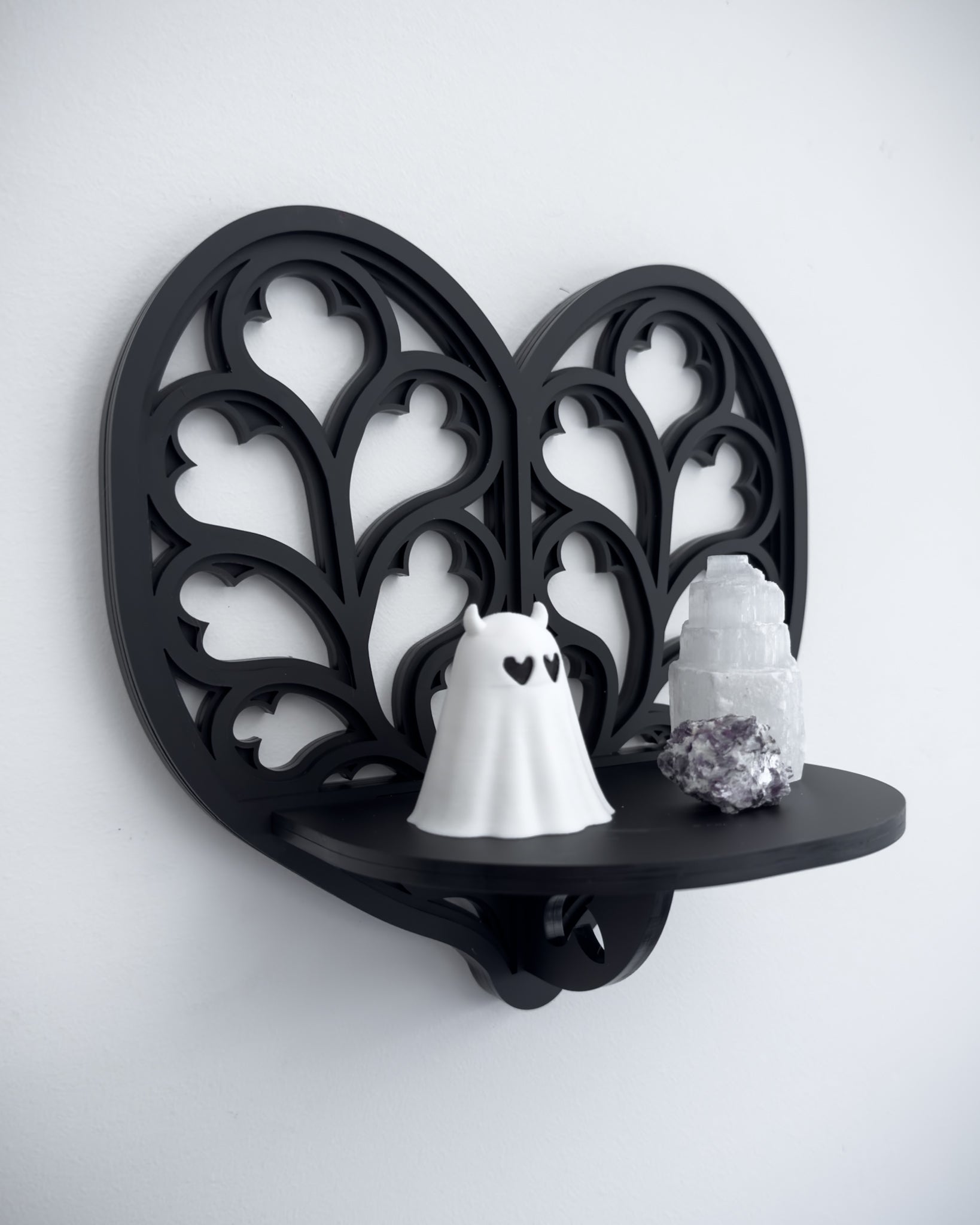 Close-up of Heart of Yorkshire cathedral tracery wall shelf in black layered acrylic holding crystals and trinkets