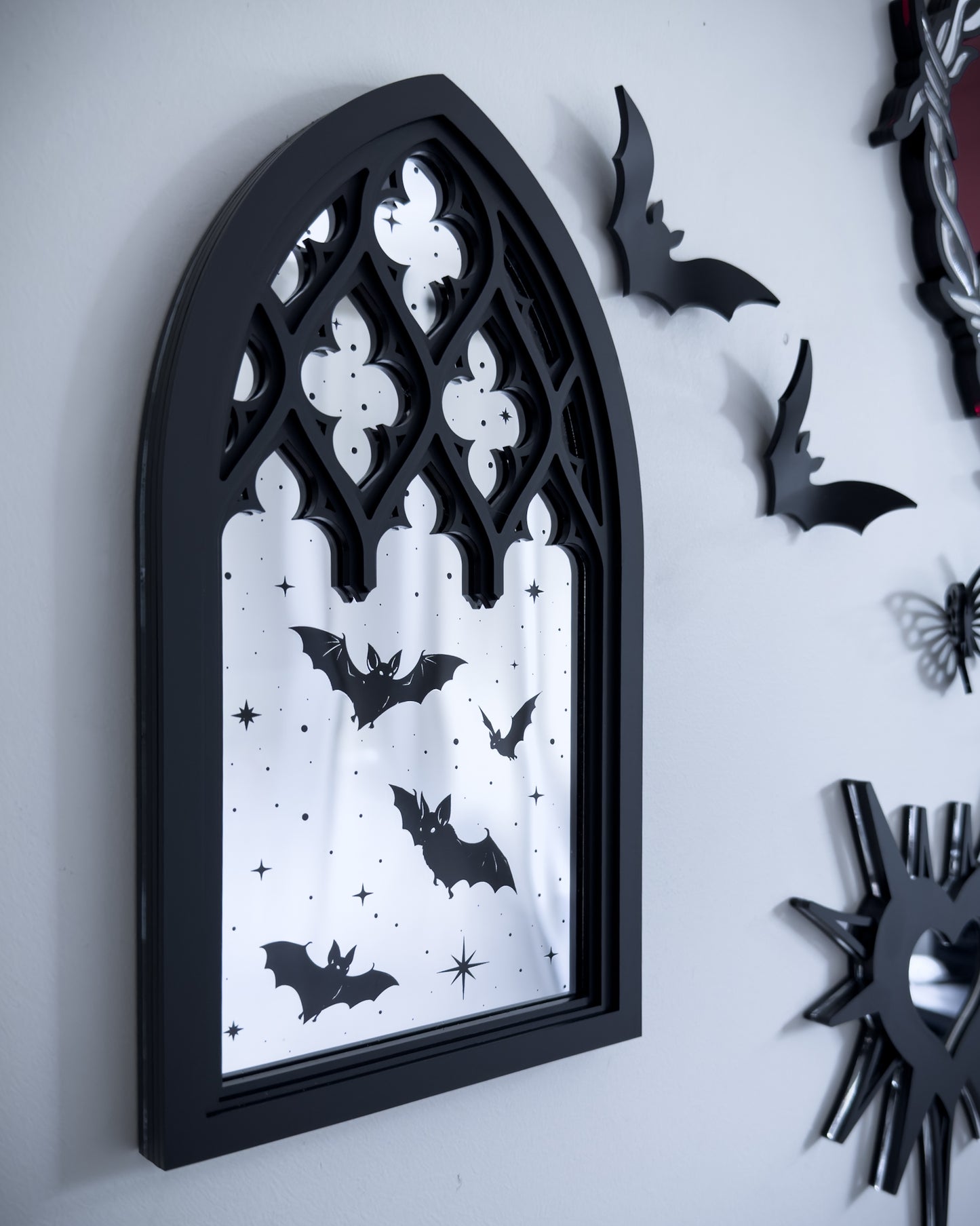 Gothic gallery wall featuring cathedral mirror wall art with bats, black acrylic decor, and flying bat wall accents