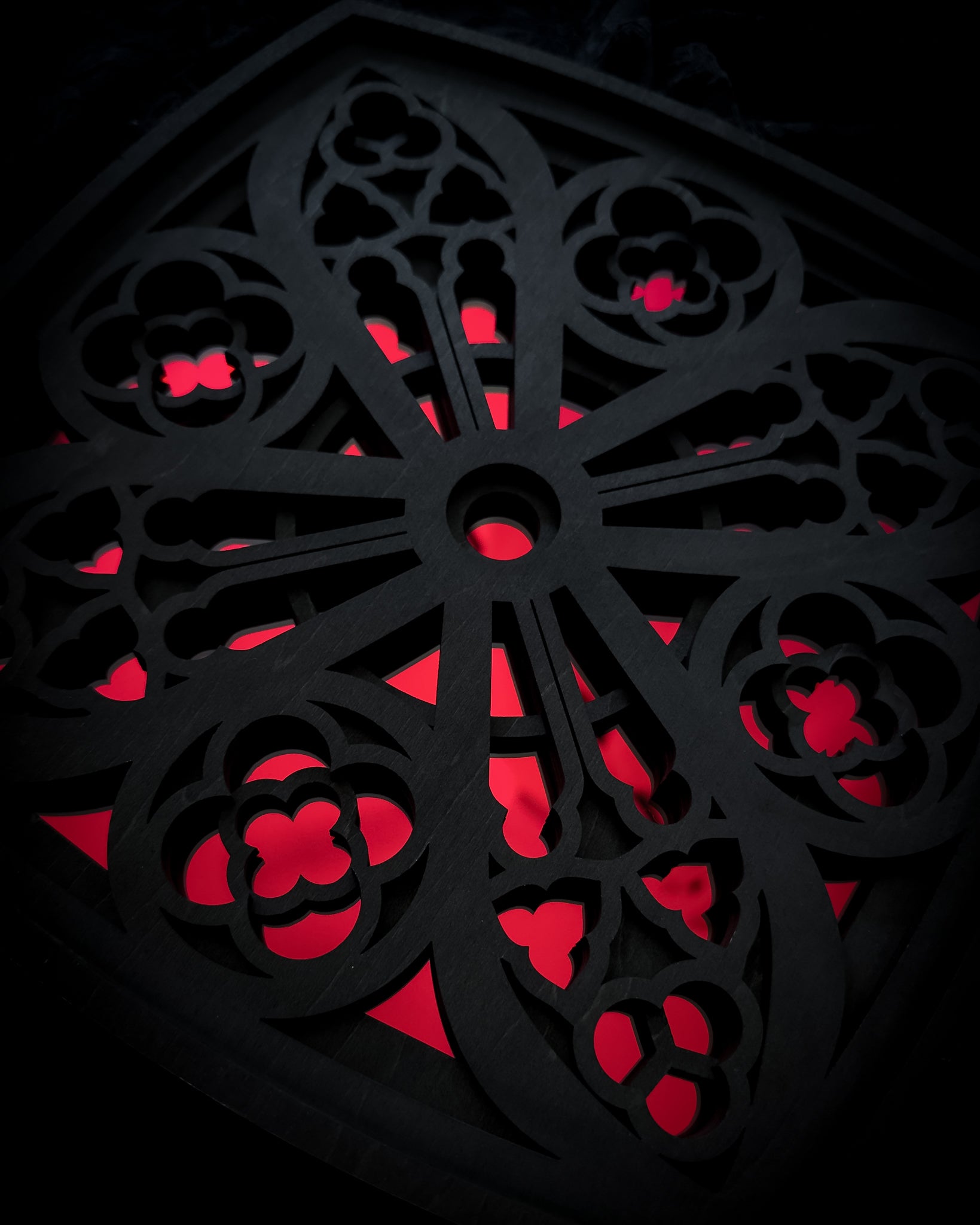Close-up detail of Cologne Cathedral window in black layered wood with red acrylic mirror centre