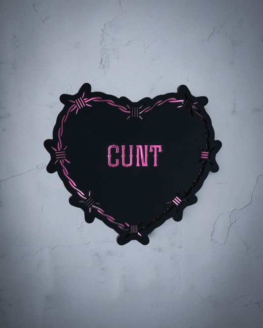 Cunt gothic heart wall art with barbed wire design in pink and black acrylic on textured grey wall