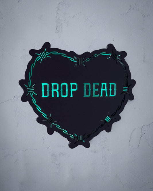 Drop Dead gothic heart wall art with barbed wire design in green and black acrylic on textured grey wall