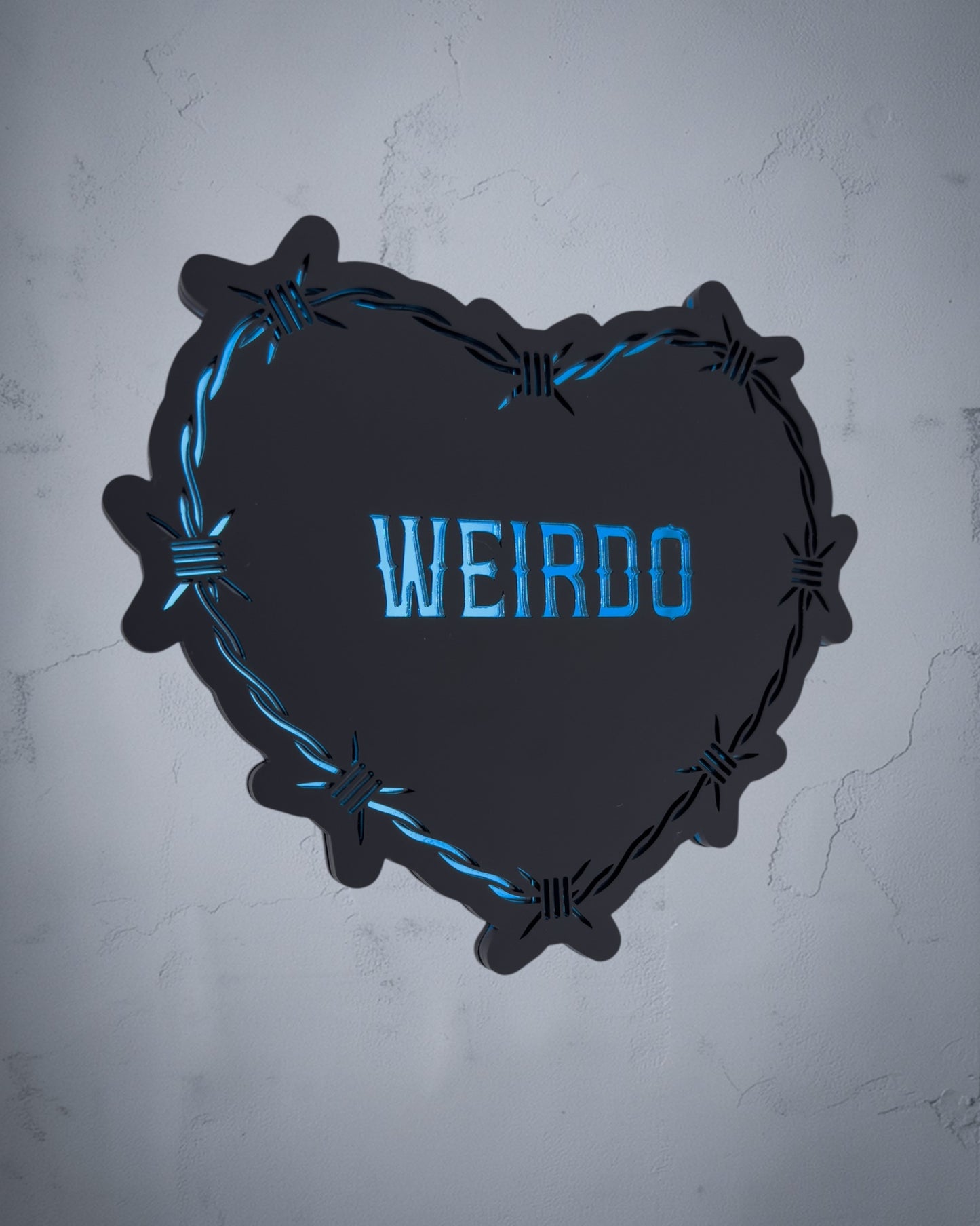Weirdo gothic heart wall art with barbed wire design in blue and black acrylic on textured grey wall