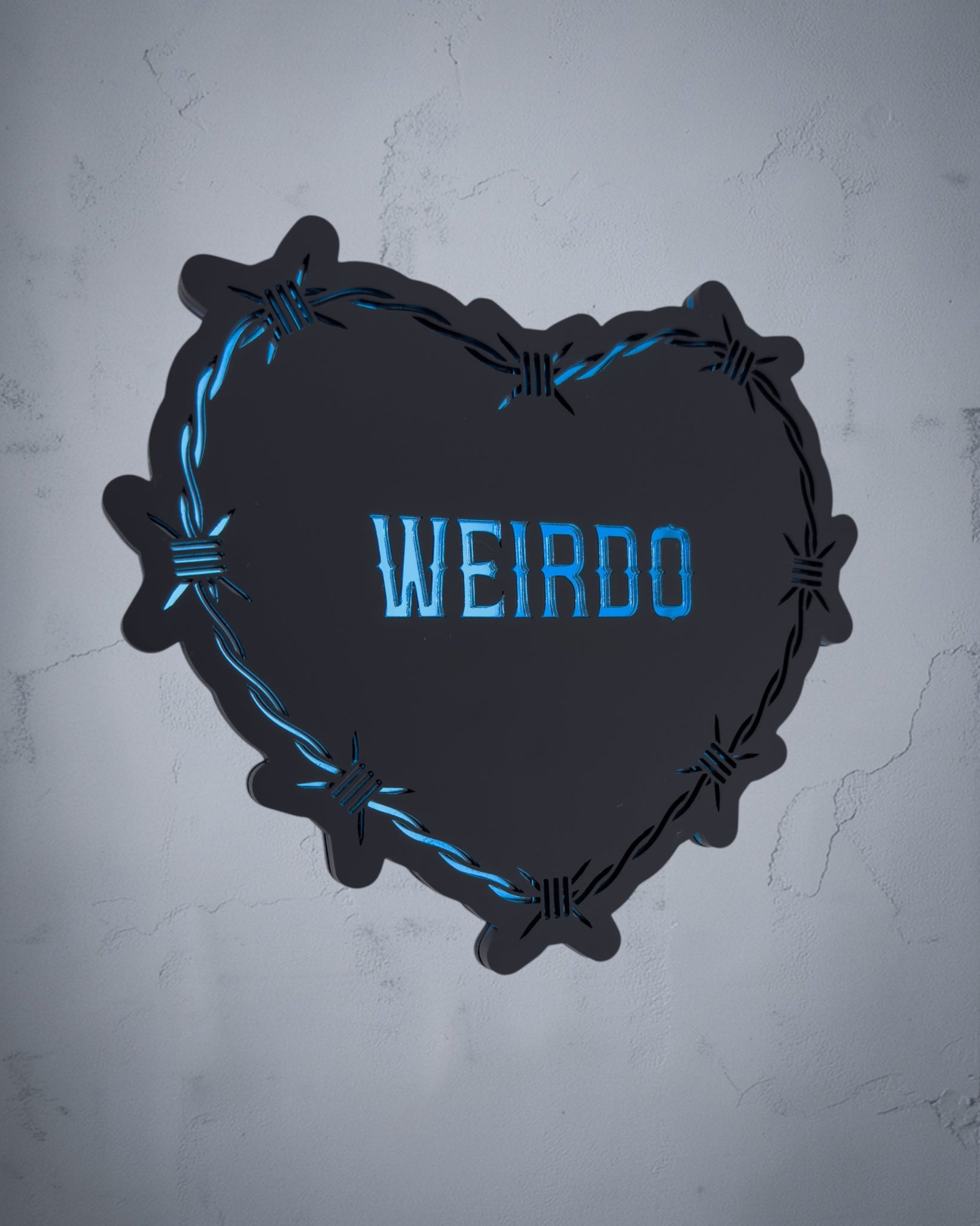 Weirdo gothic heart wall art with barbed wire design in blue and black acrylic on textured grey wall