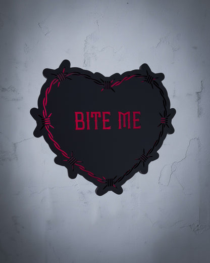 Bite Me gothic heart wall art with barbed wire design in red and black acrylic on textured grey wall