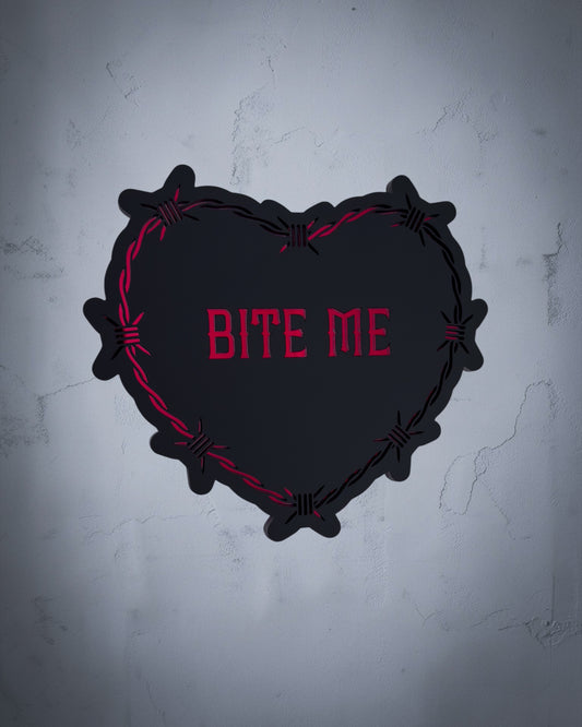 Bite Me gothic heart wall art with barbed wire design in red and black acrylic on textured grey wall