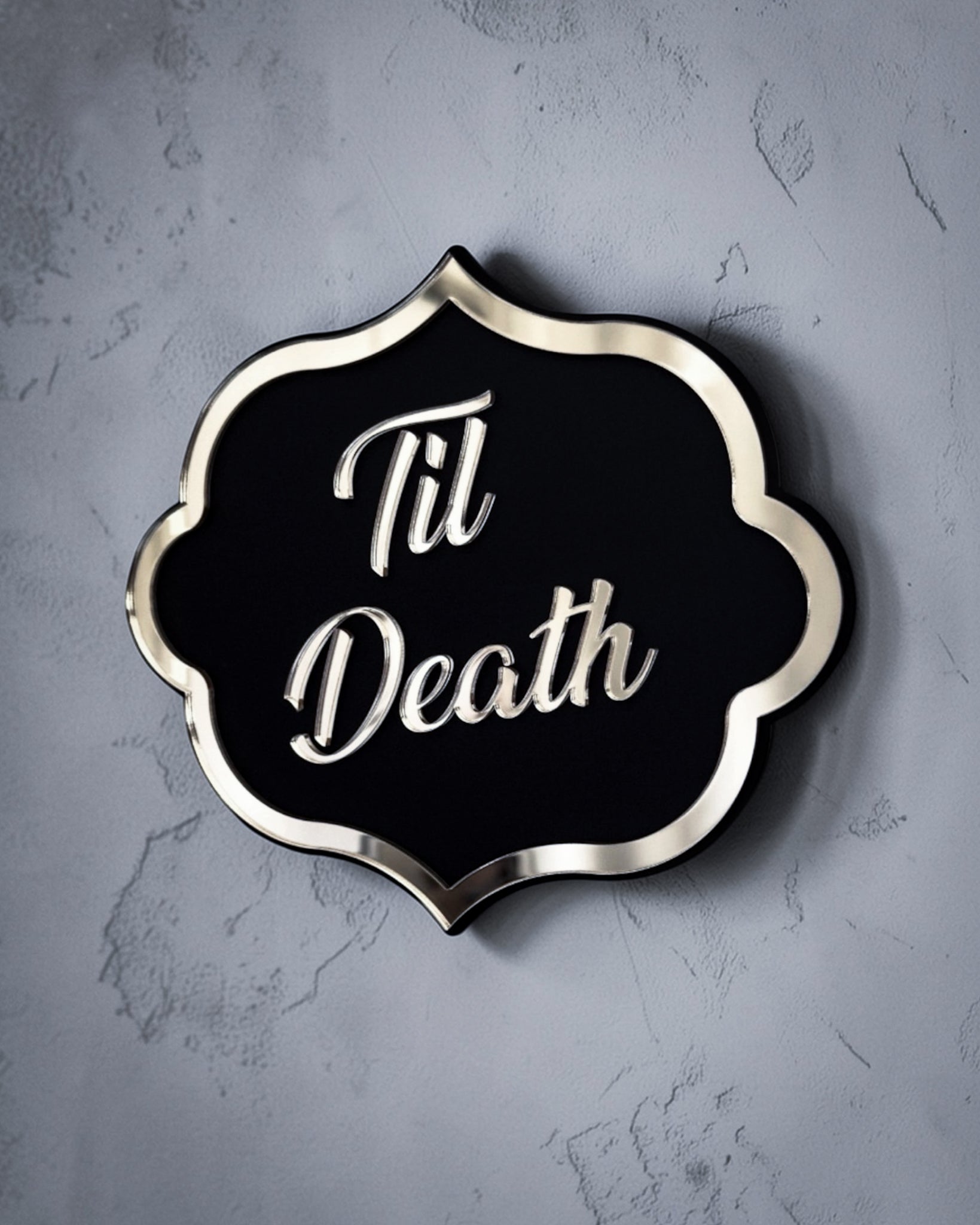 Side view of Til death gothic wall art plaque in gold mirror on textured grey wall