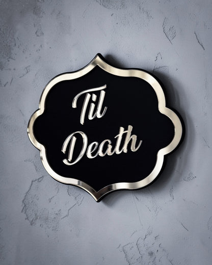 Side view of Til death gothic wall art plaque in gold mirror on textured grey wall