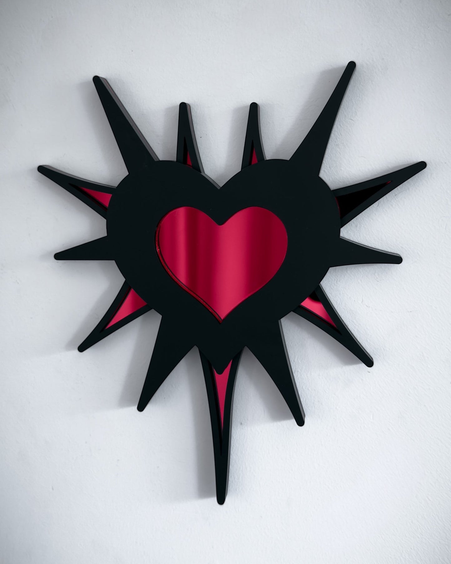 Gothic spiked barb heart mirror in black acrylic with red mirrored centre, wall mounted
