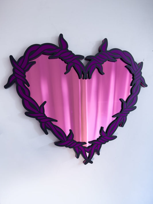 Close-up of purple and pink barbed wire heart mirror in layered acrylic gothic wall decor