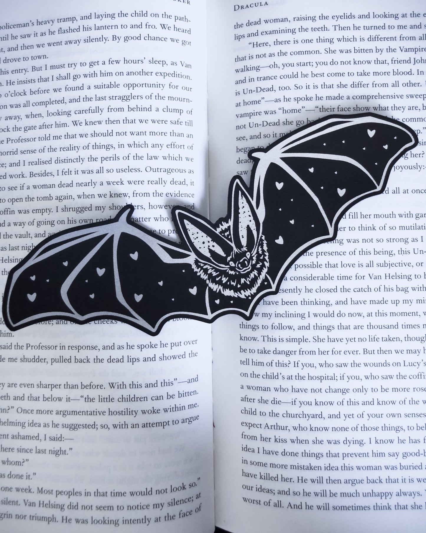 Gothic bat bookmark in black and silver leatherette with heart detail, resting on an open book
