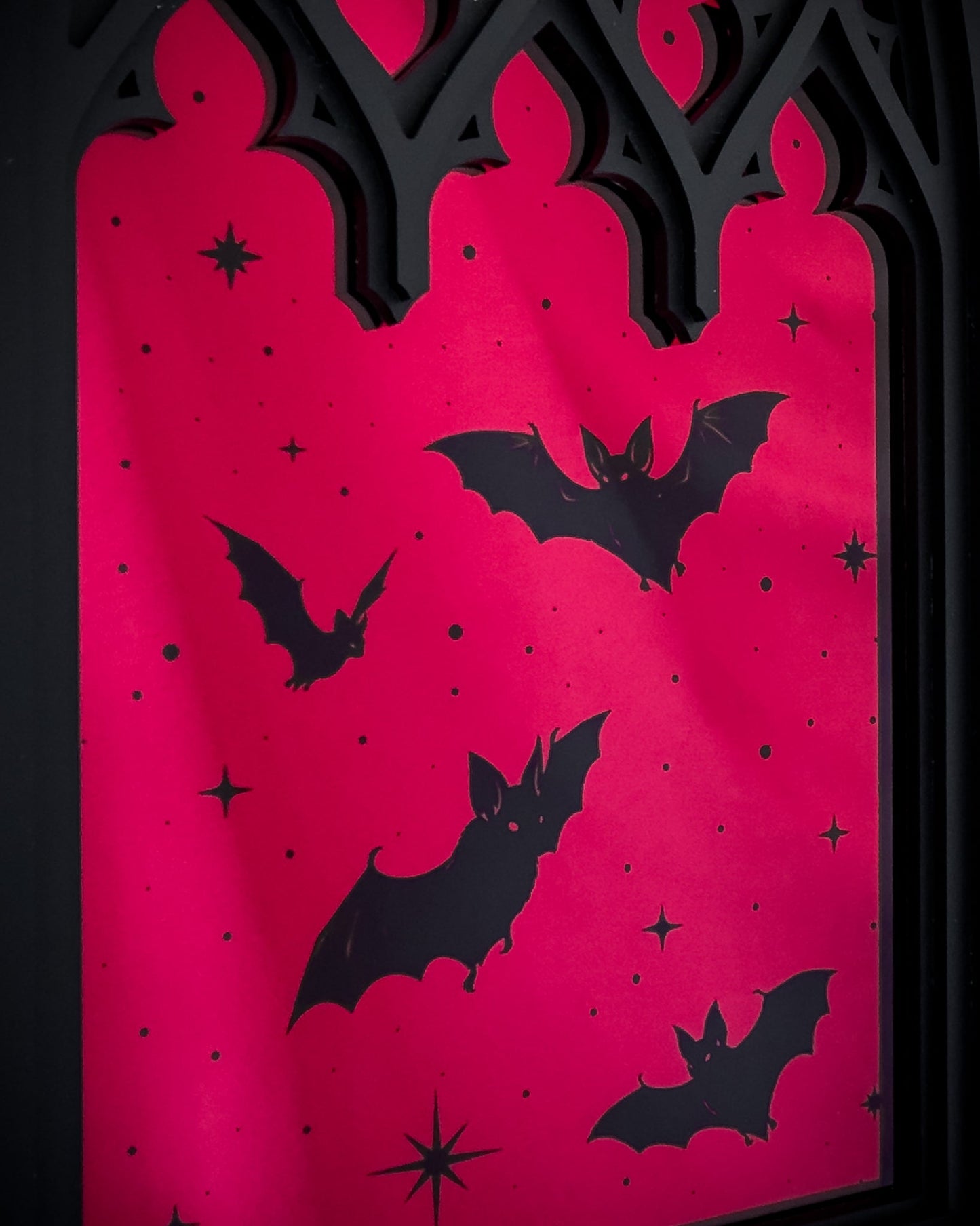 Close-up of Gothic cathedral window mirror with red acrylic and bat silhouettes