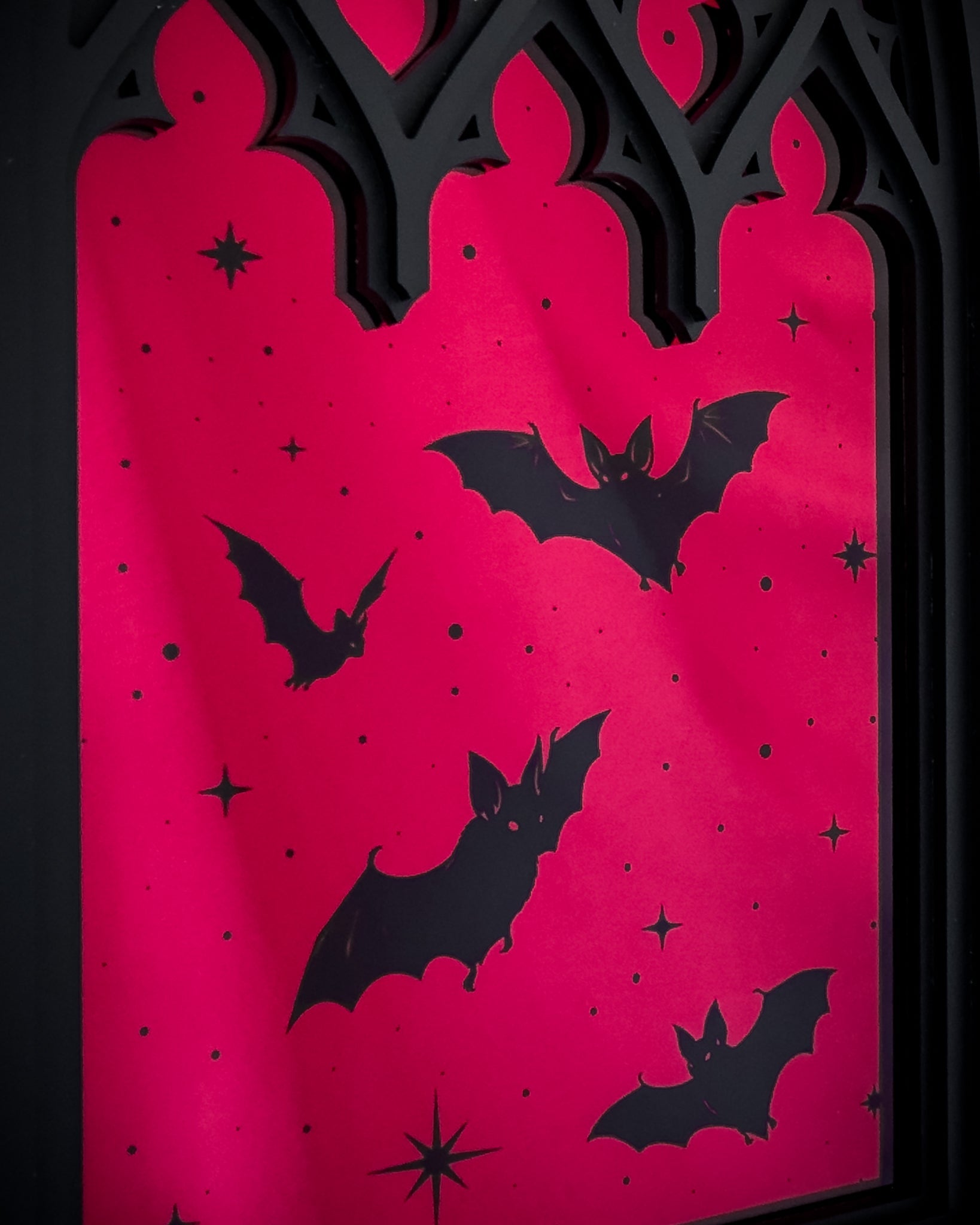 Close-up of Gothic cathedral window mirror with red acrylic and bat silhouettes
