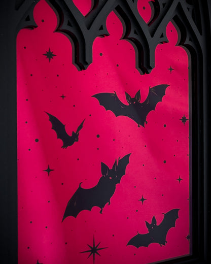 Close-up of Gothic cathedral window mirror with red acrylic and bat silhouettes