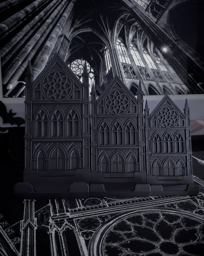 Large, medium, small Black gothic cathedral device stands on a table with cathedral interior imagery in the background
