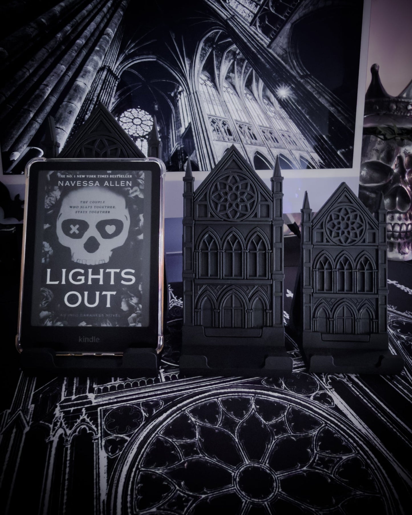 Black gothic cathedral device stands holding an e-reader on a table with cathedral interior imagery in the background