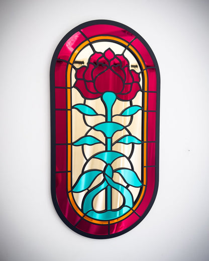 Gothic stained glass rose window mirror with red, gold and green acrylic on a white wall