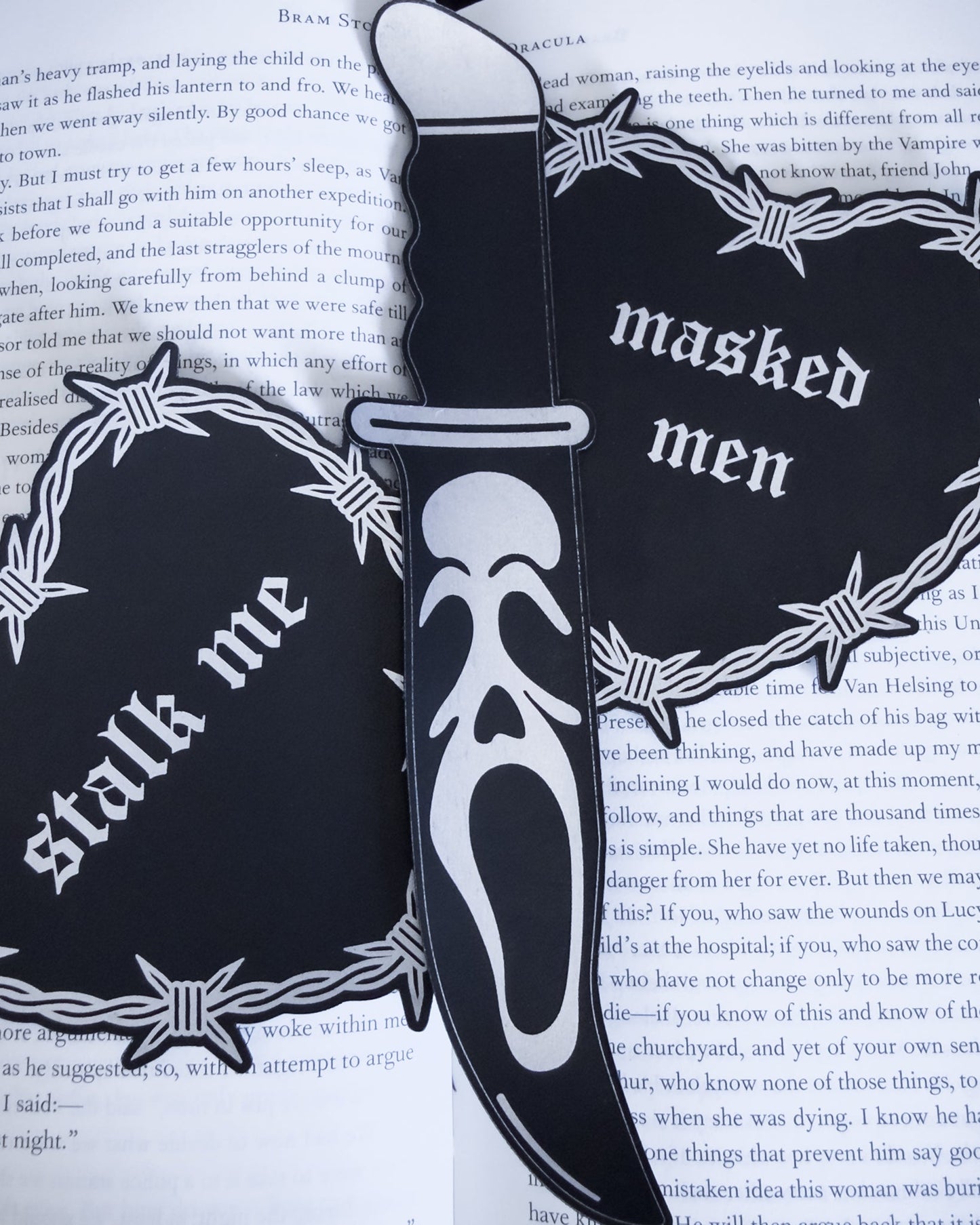 Ghostface knife bookmark in black leatherette resting on an open book