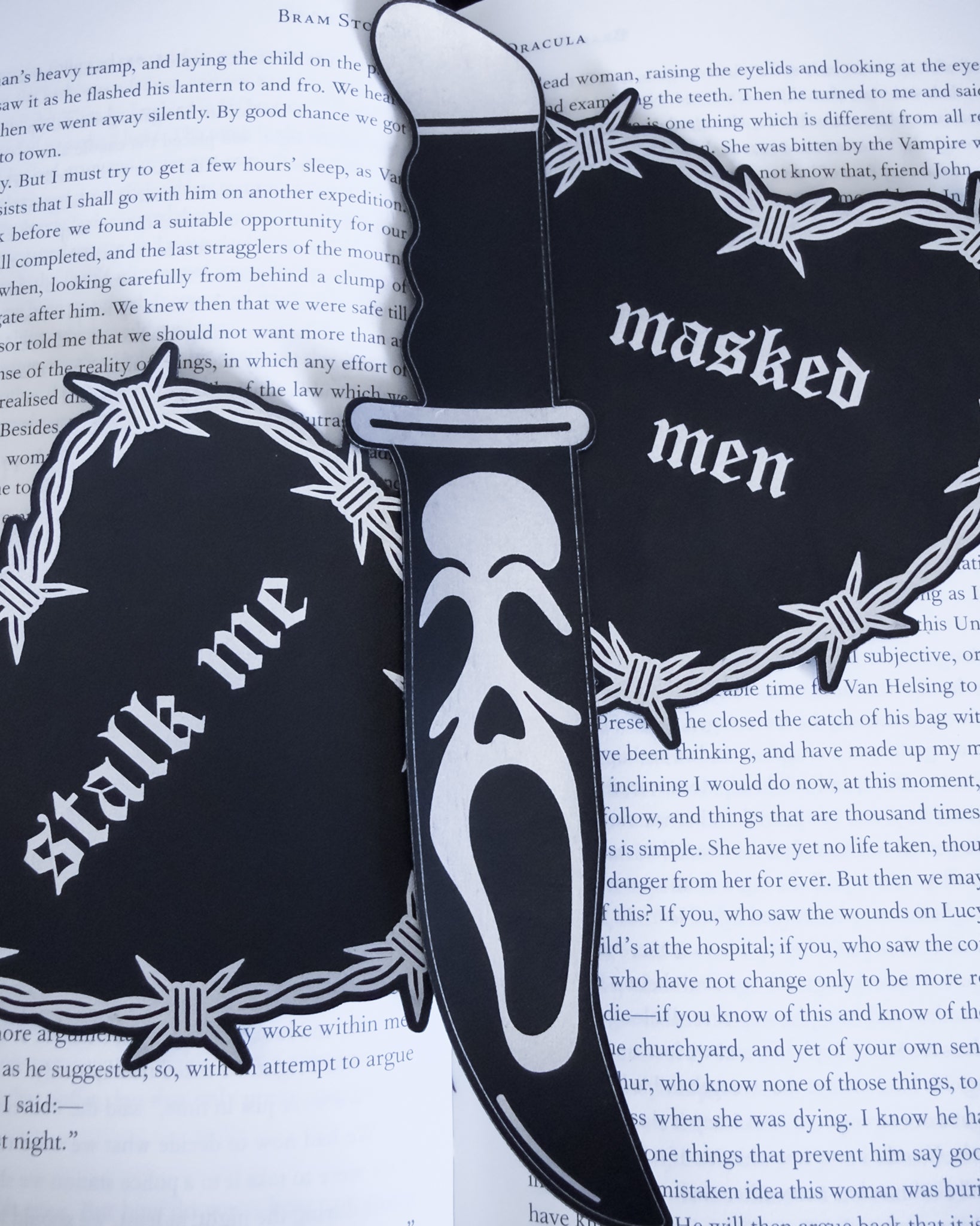 Ghostface knife bookmark in black leatherette resting on an open book