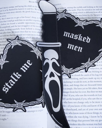 Ghostface knife bookmark in black leatherette resting on an open book
