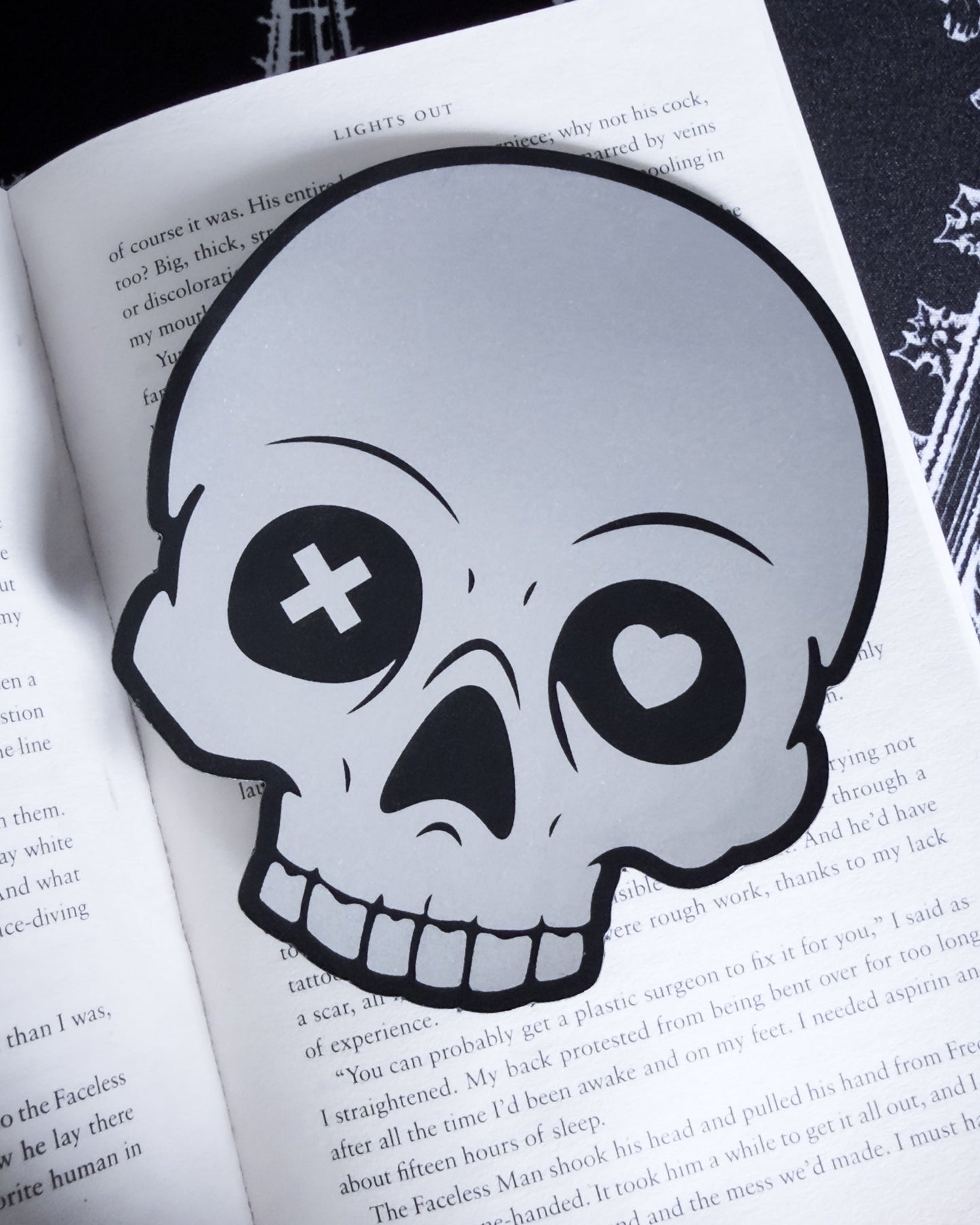 Gothic skull bookmark in black and silver leatherette, in a open book