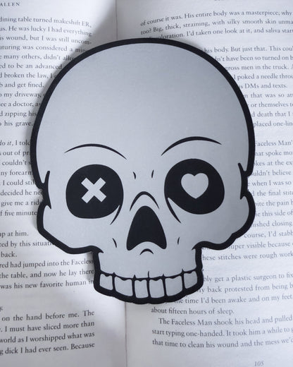 Gothic skull bookmark in black and silver leatherette, resting in a open book