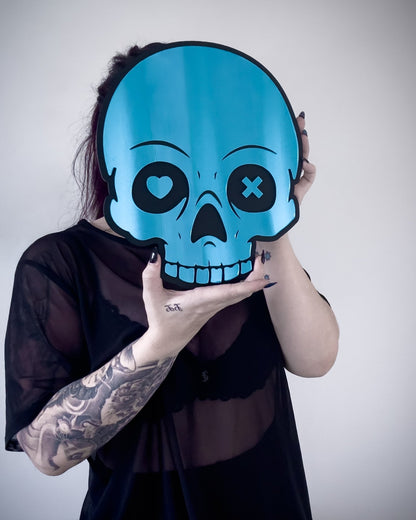 Blue skull mirror with heart and X eyes held by person for size reference