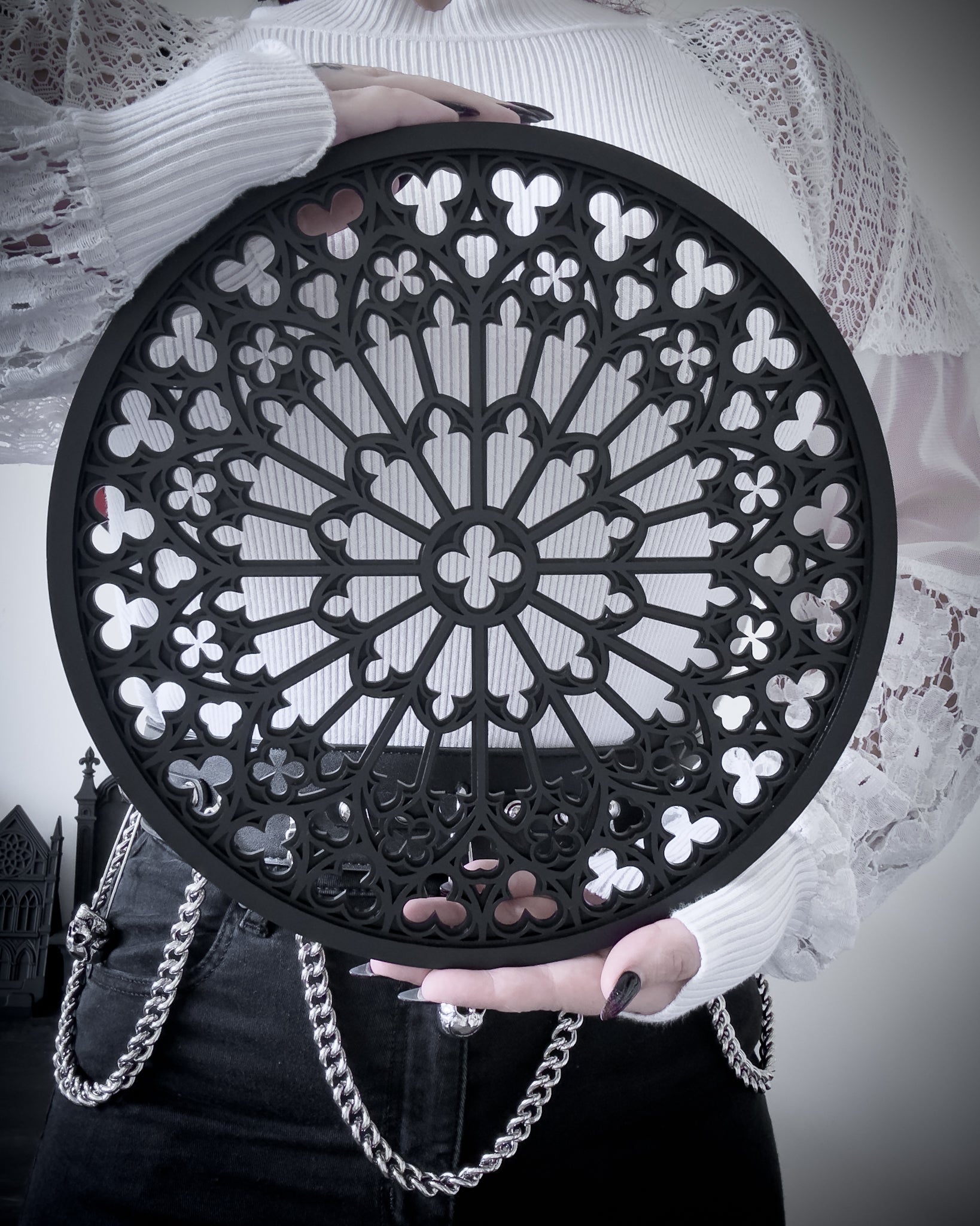 Notre Dame rose window tracery wall art in black layered acrylic, held for size reference