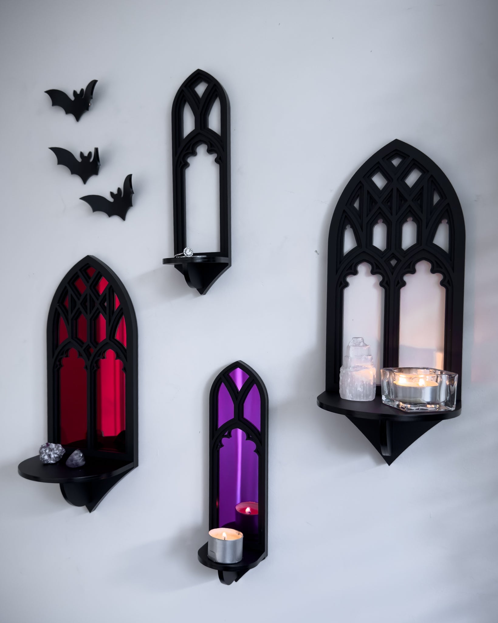 Gallery wall featuring Salem gothic tracery wall shelves with acrylic bats on a white wall with candle and trinket display