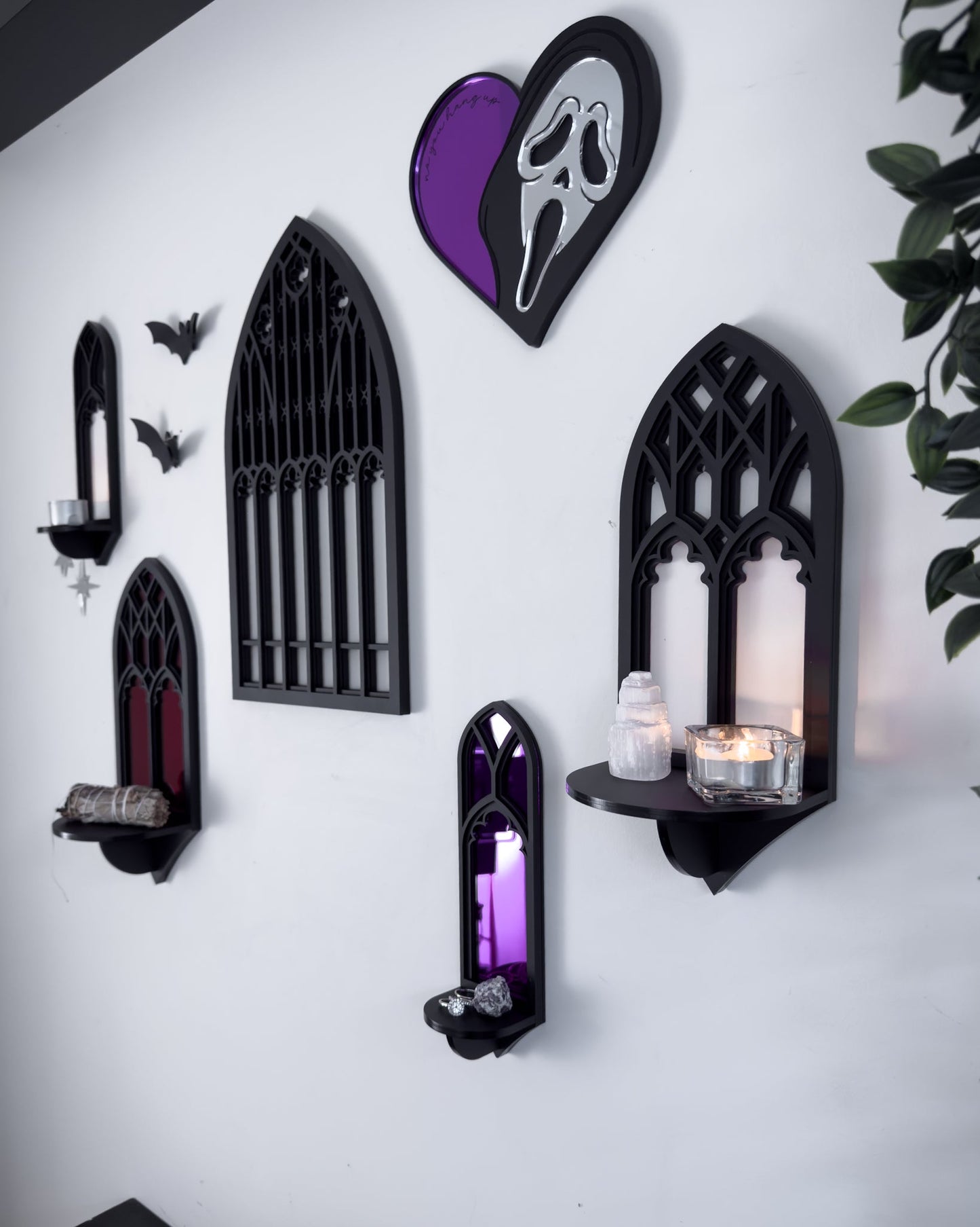 Side view of gallery wall featuring Salem gothic tracery wall shelves with acrylic bats and Ghostface mirror on a white wall