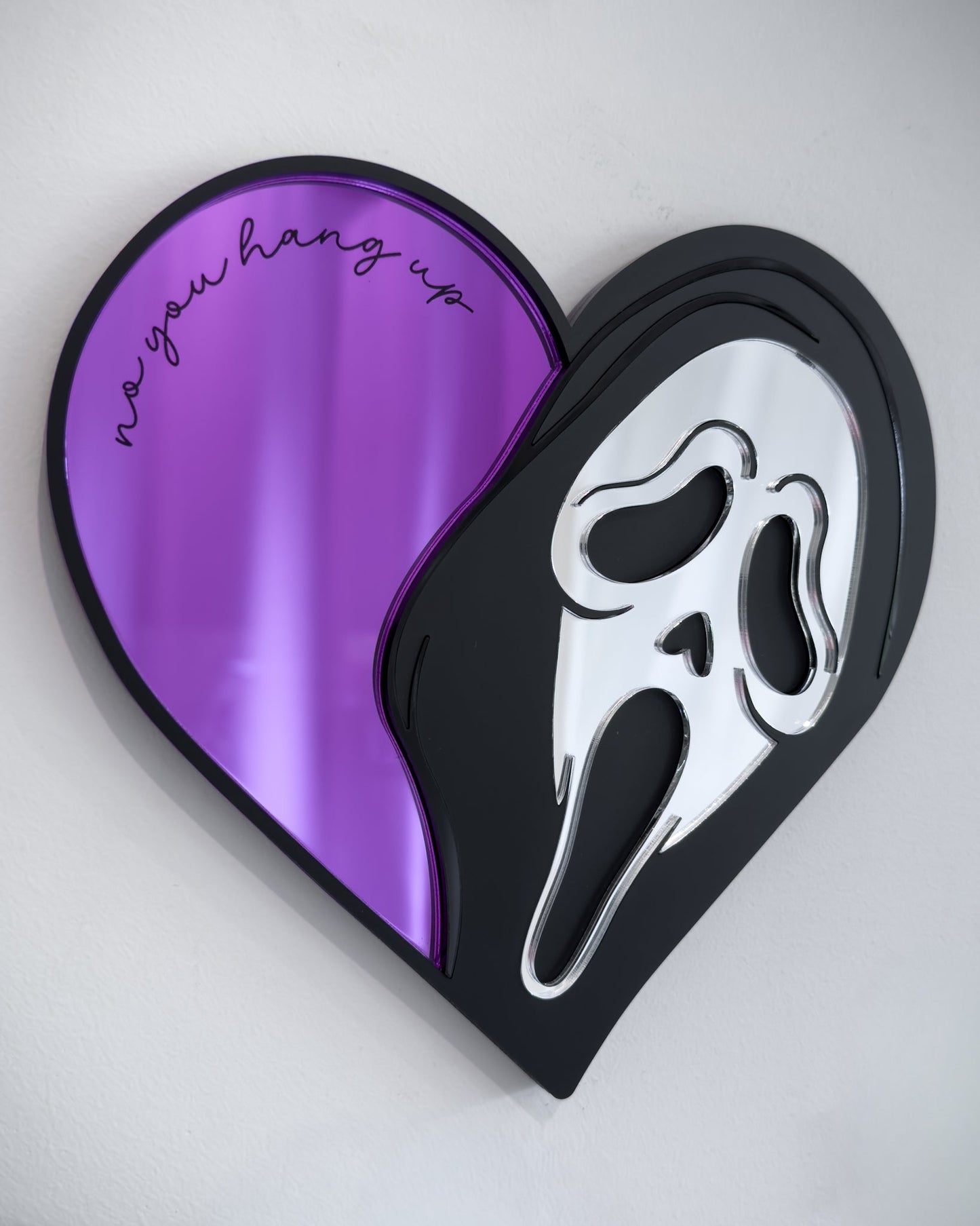 Ghostface heart mirror with purple acrylic and engraved text “no you hang up” mounted on a white wall