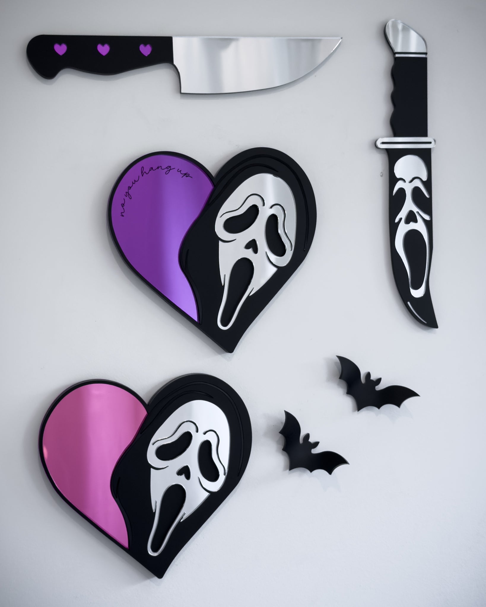 Ghostface heart mirrors in pink and purple acrylic styled on a gallery wall with knife mirrors and bat wall decor
