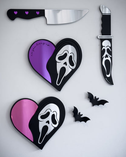 Ghostface heart mirrors in pink and purple acrylic styled on a gallery wall with knife mirrors and bat wall decor