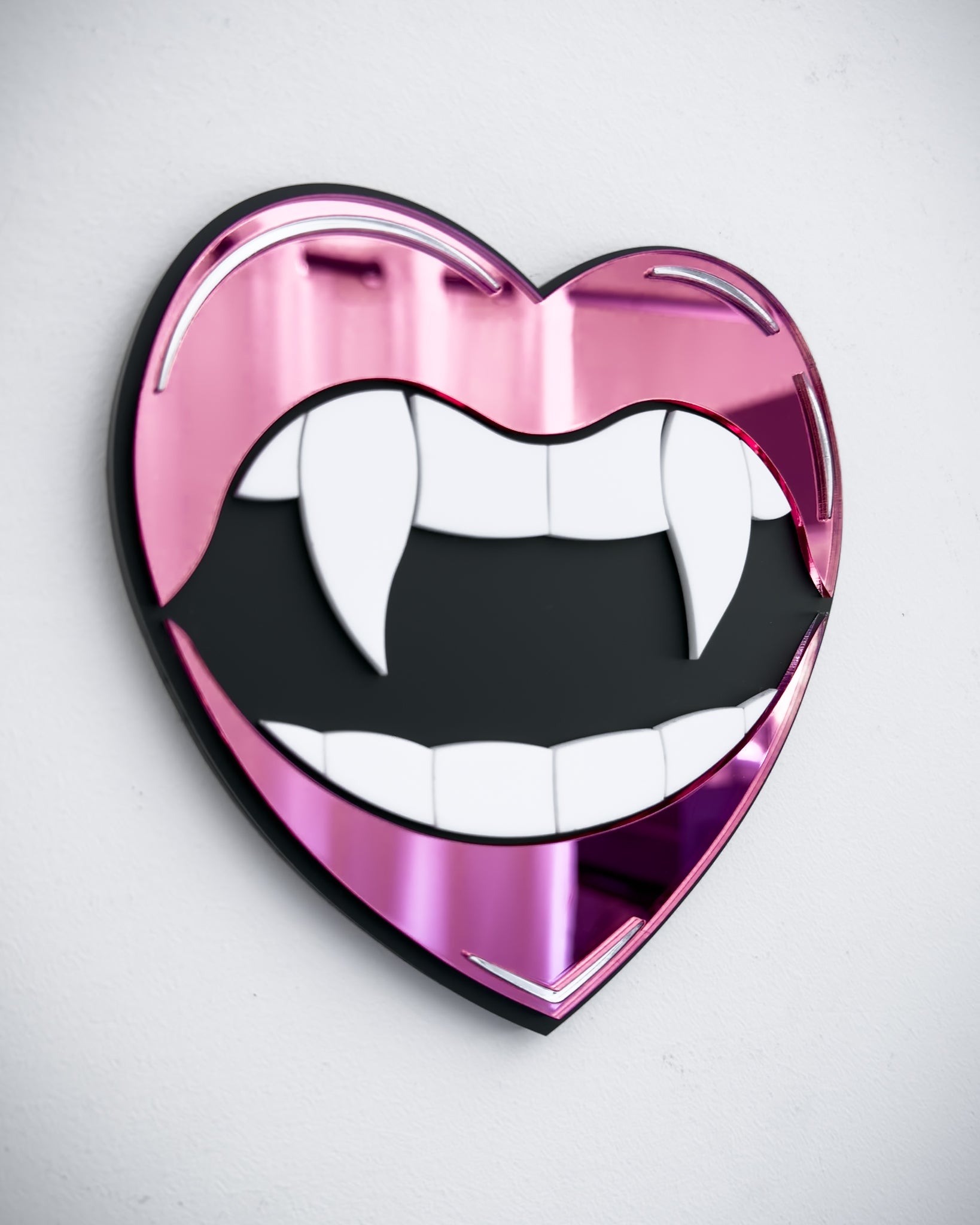 Side view of Gothic vampire lips mirror wall art in pink acrylic with fangs and black centre